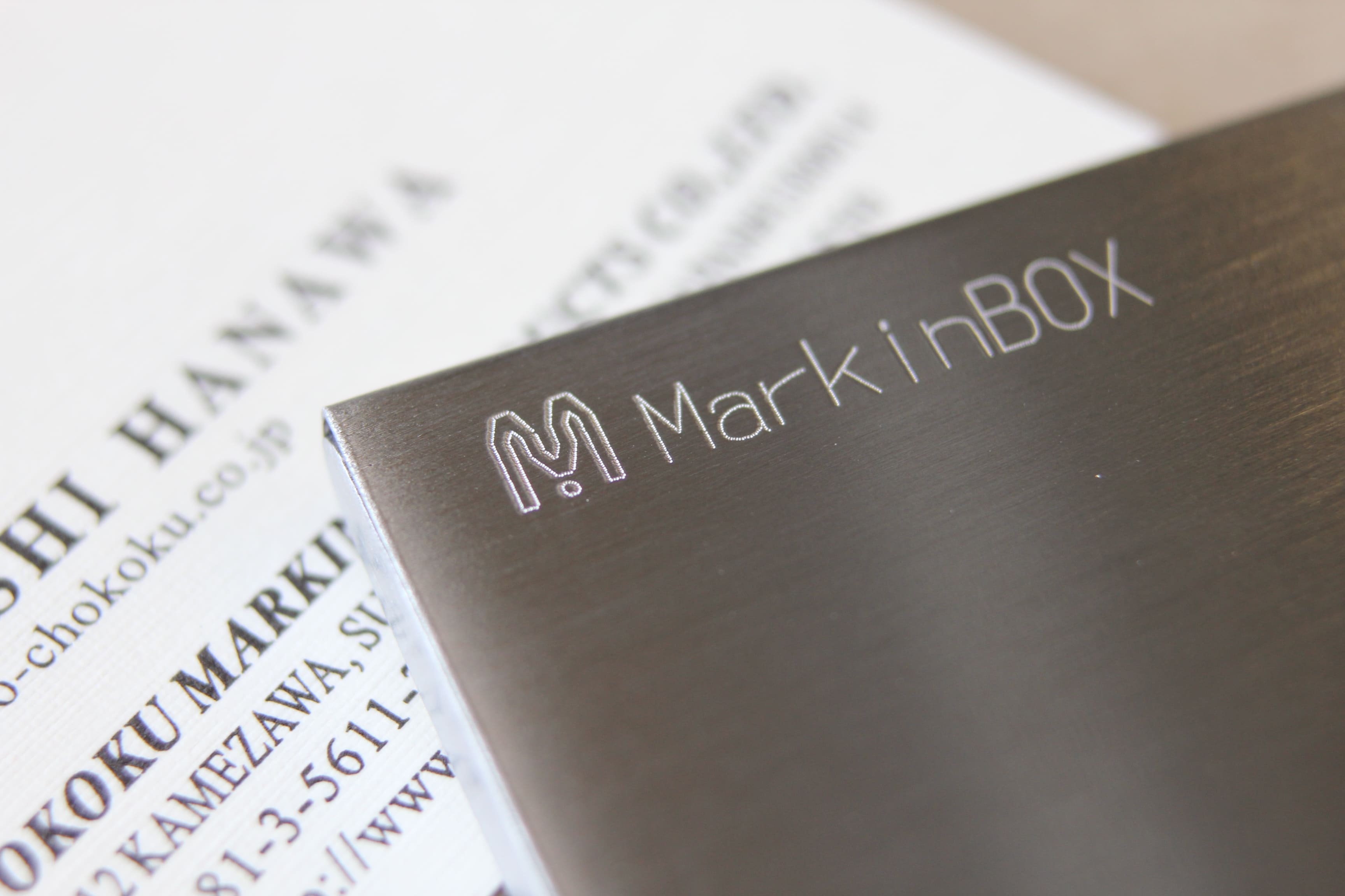 Image of stainless steel case engraved with 'MarkinBOX' and logo
