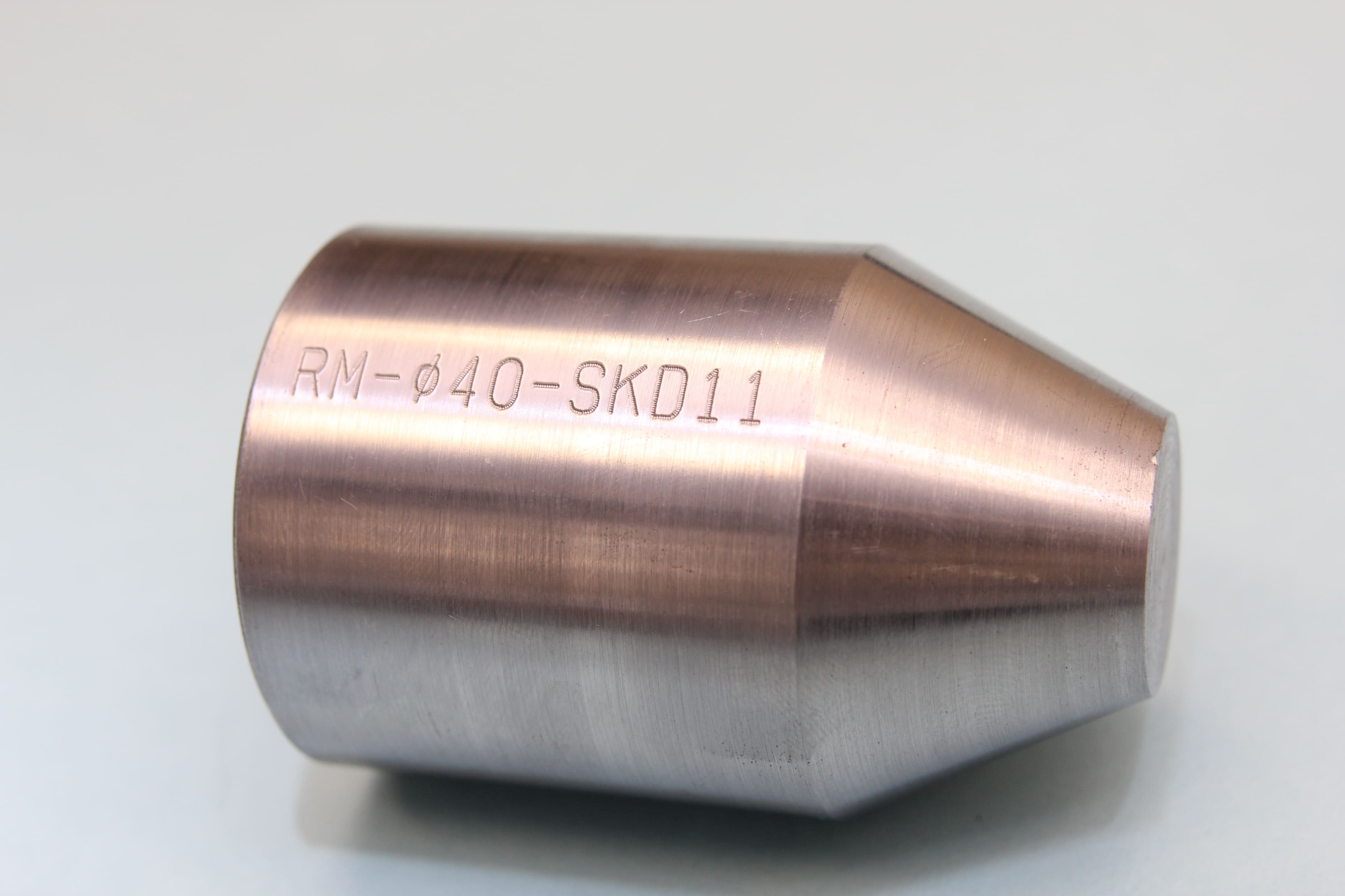 Image of round parts engraved with text and numbers 'RM-Ø40-SKD11'.