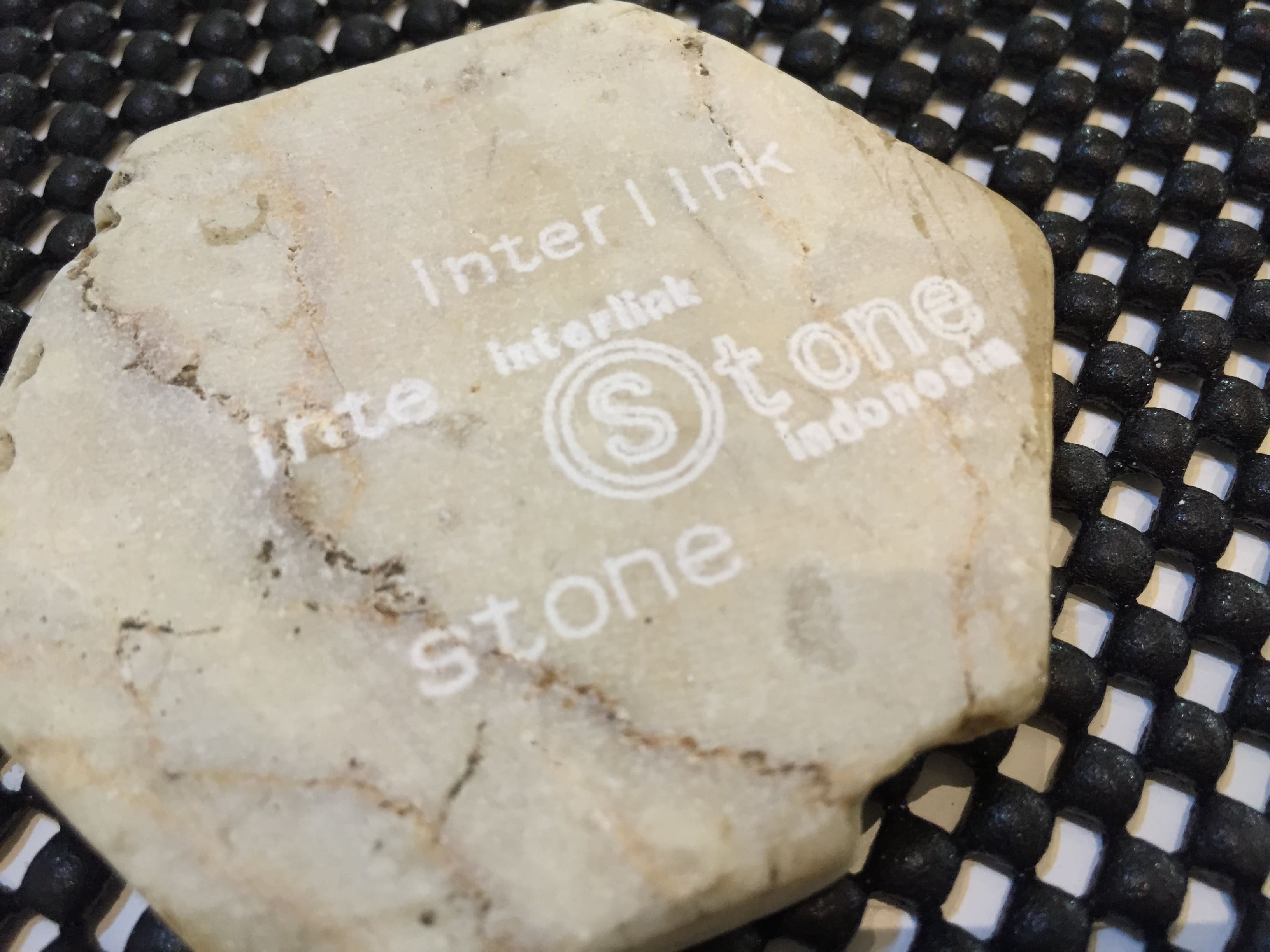 Image of stone engraved with text 'interlink stone indonesia' and logo