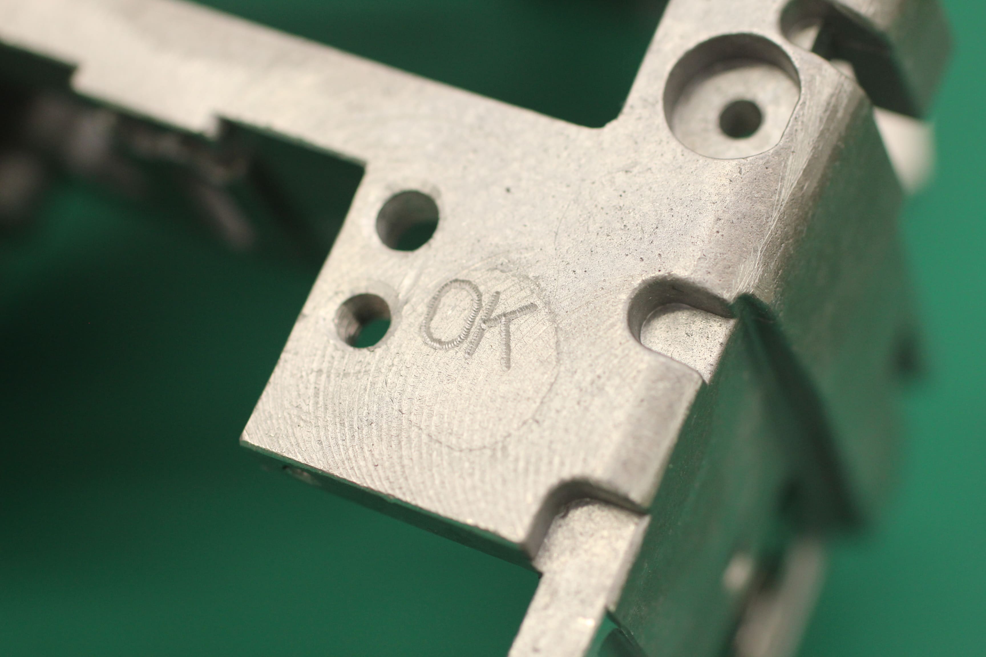 Image of an aluminum cast with the word 'OK' engraved on it.