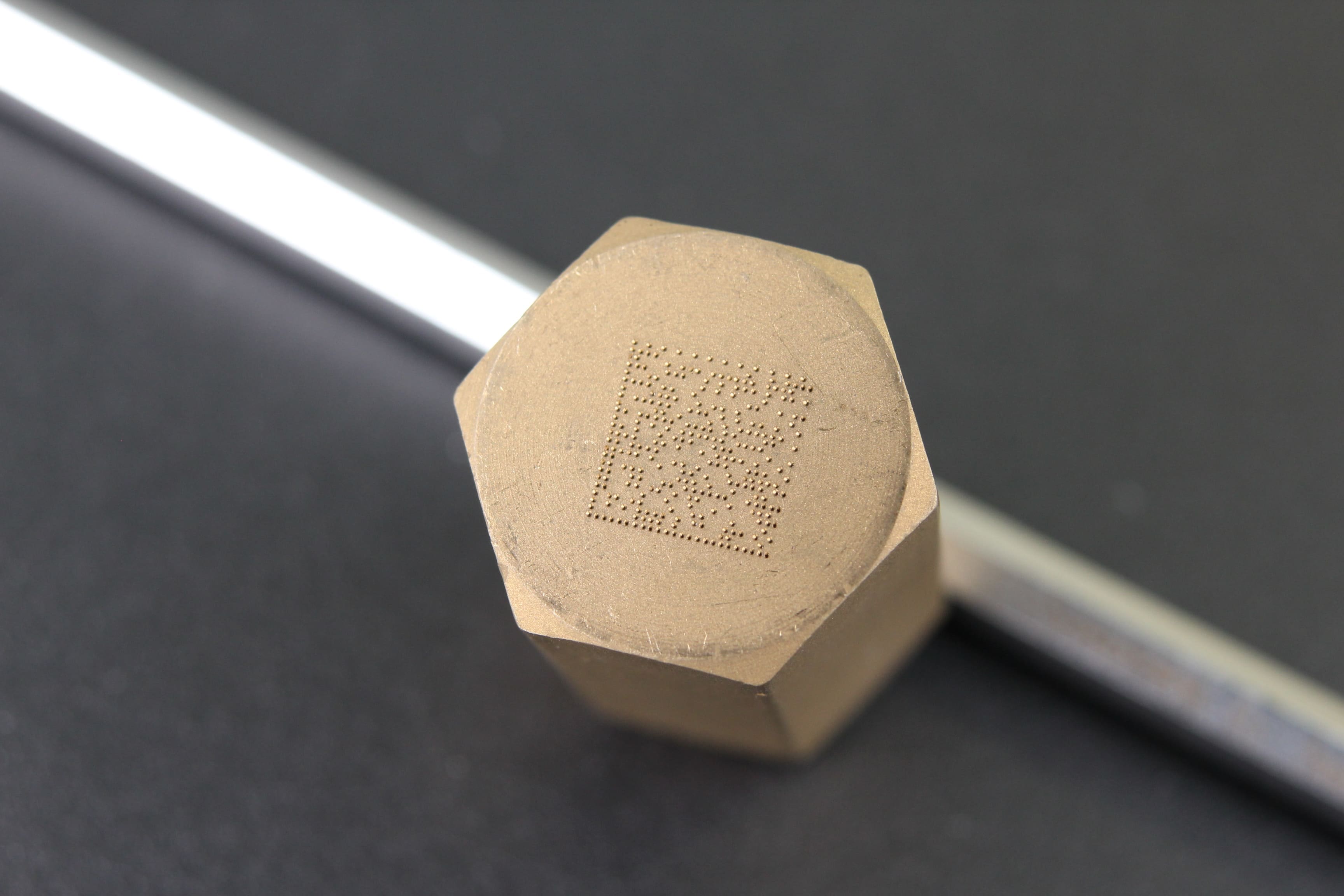 Image of brass material engraved with QR code